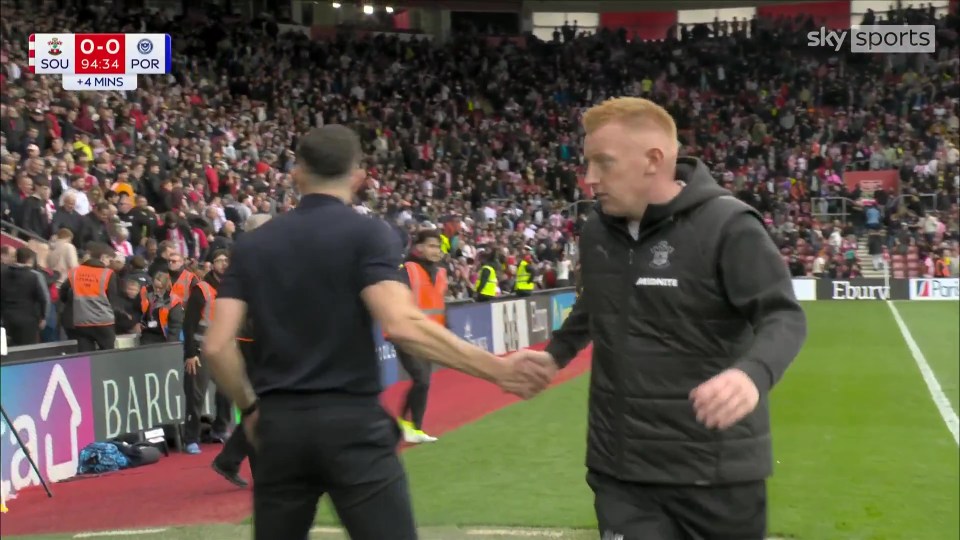 John Mousinho and Will Still shaking hands.