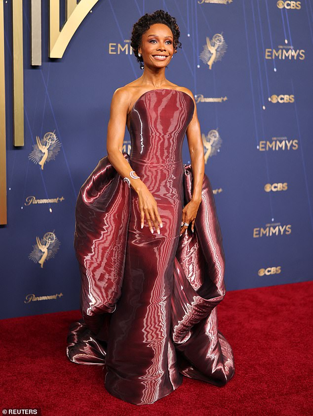 TV personality Zuri Hall, 37, who often co-hosts on American Ninja Warrior, took to the Emmy red carpet in an unusual maroon ensemble that featured a curved bodice and oodles of extra material bunched at the hips