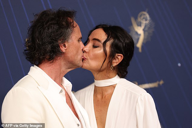 Walton shared a kiss with his wife as they took a break from posing for the cameras