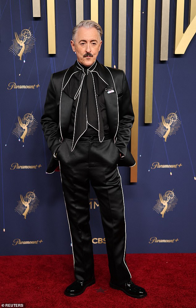 Scottish actor Alan Cumming put on a striking display in a black satin suit with white lace lining and a huge cravat
