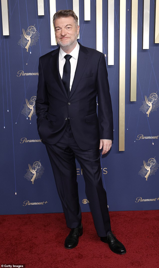 Charlie looked dapper for the evening in a dark blue satin suit with a matching tie, while Bisha wore a chic black suit featuring metal cross buttons