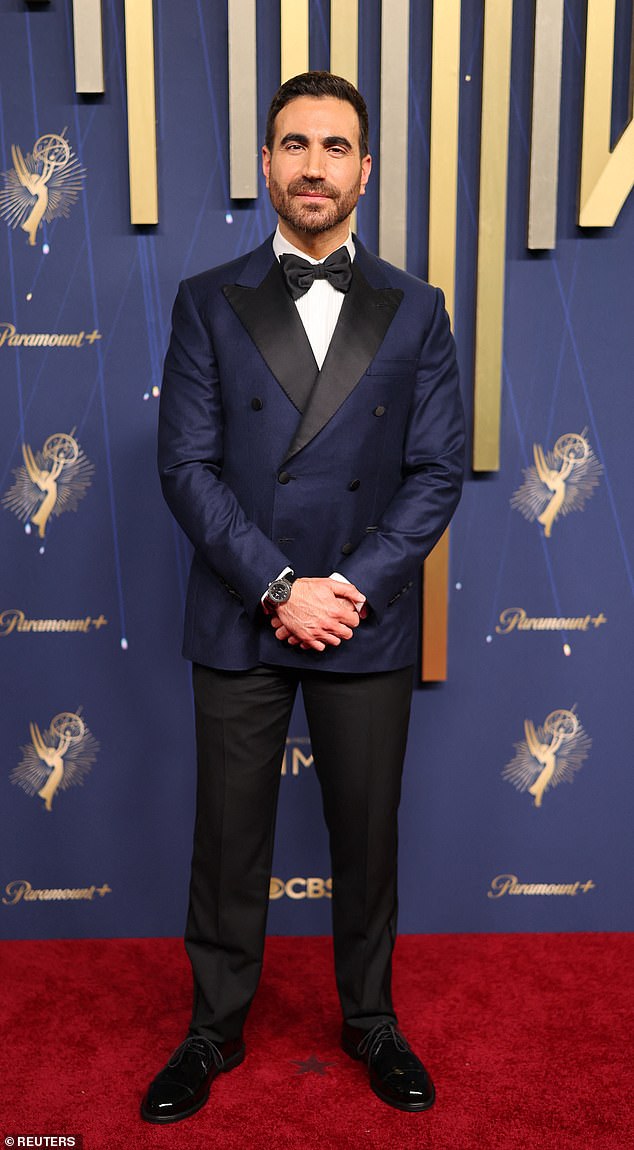Ted Lasso actor Brett Goldstein looked dapper in a navy sheen blazer featuring black buttons and a black collar, as well as a bow tie
