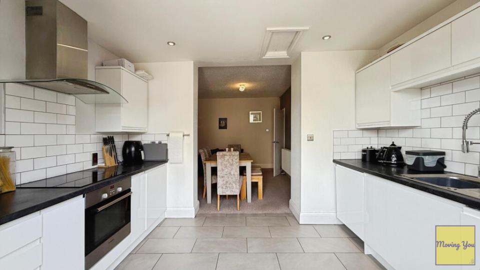 Interior view of a kitchen and dining area with a visible toilet in the utility room.