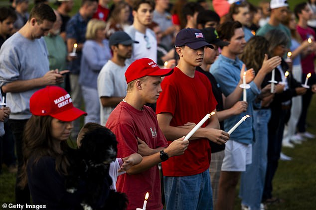 A vigil in Provo, Utah, holding candles and wearing patriotic clothing