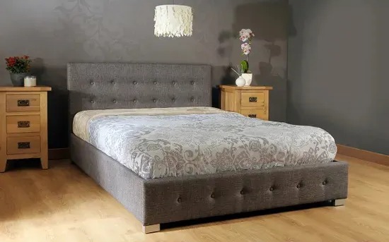 Grey upholstered bed with button tufting.