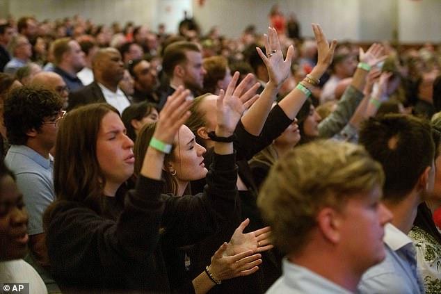 People sing and pray during a memorial and prayer vigil for Charlie Kirk at the John F. Kennedy Memorial Center for the Performing Arts, Sunday, Sept. 14, 2025, in Washington