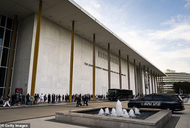 People wait in line prior to a prayer vigil for political activist Charlie Kirk outside the John F. Kennedy Center for the Performing Arts on September 14, 2025 in Washington, DC. Kirk was shot and killed by a gunman on September 10 while speaking at Utah Valley University