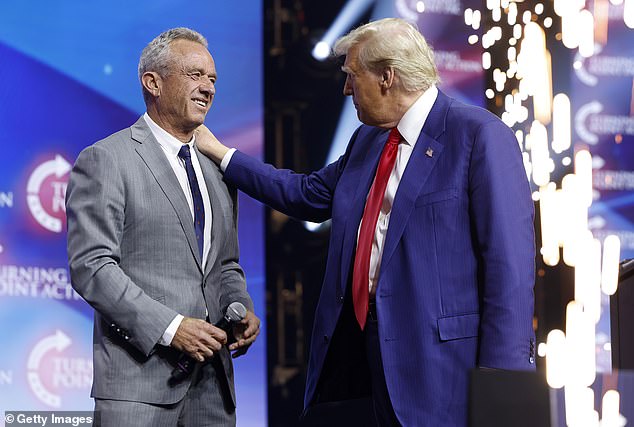 Donald Trump welcomes Robert F. Kennedy Jr. to the stage at a Turning Point Action campaign rally at the Gas South Arena on October 23, 2024 in Duluth, Georgia