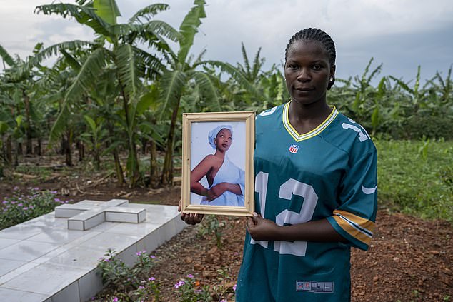 Ronah, Monic Karungi's niece, holds a photograph of her aunt who died in May 2022