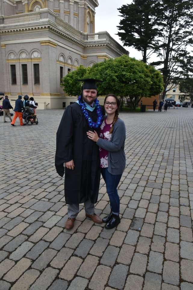 Graduate in cap and gown with his wife.