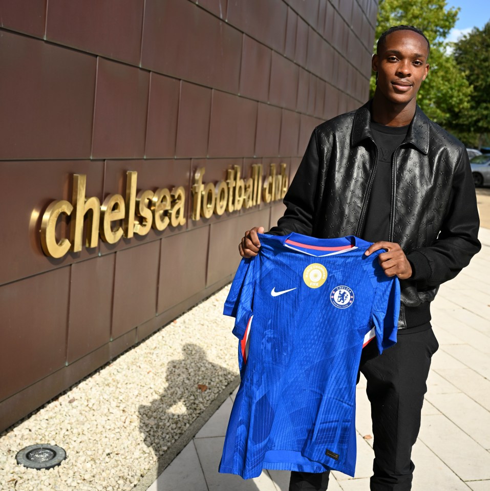 Emanuel Emegha holding a Chelsea jersey.