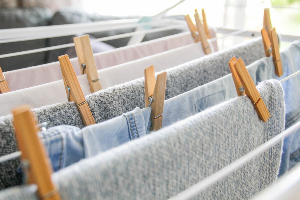 Clothes drying on an indoor rack with wooden clothespins.