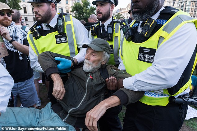 Protesters lay on the ground in Parliament Square holding signs reading 'I oppose genocide. I support Palestine Action' on Saturday, September 6