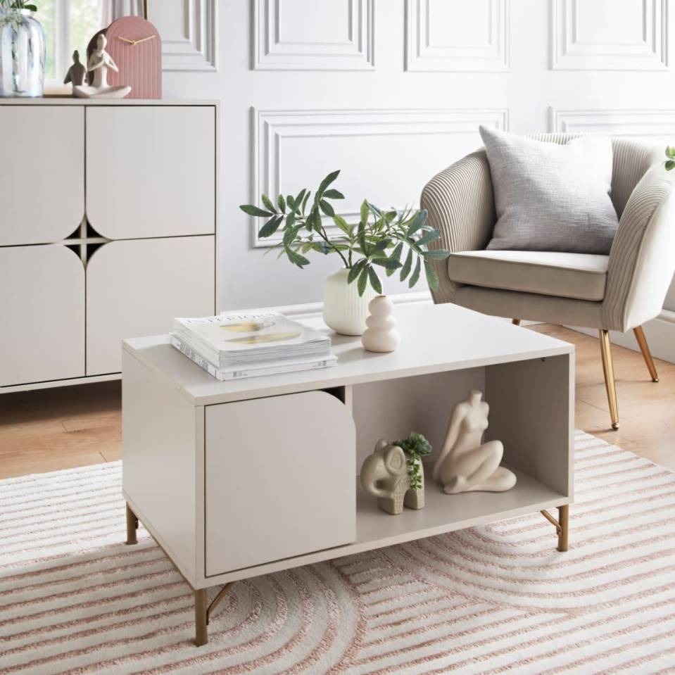 Light beige coffee table with gold legs in living room setting.