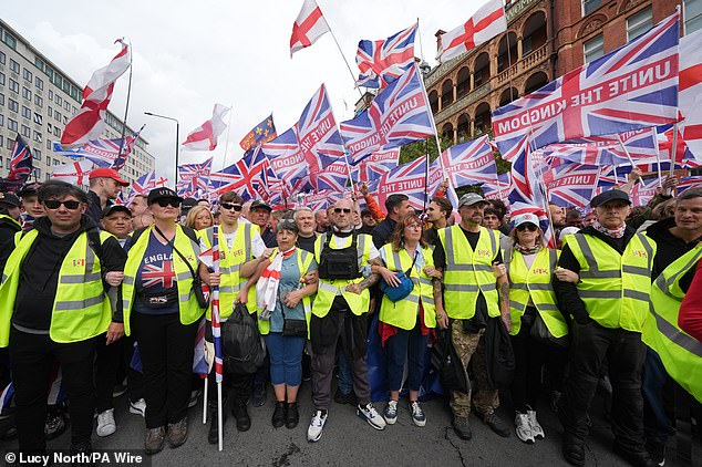 Activists hold flags during the 'Unite the Kingdom' march and rally in London on Saturday