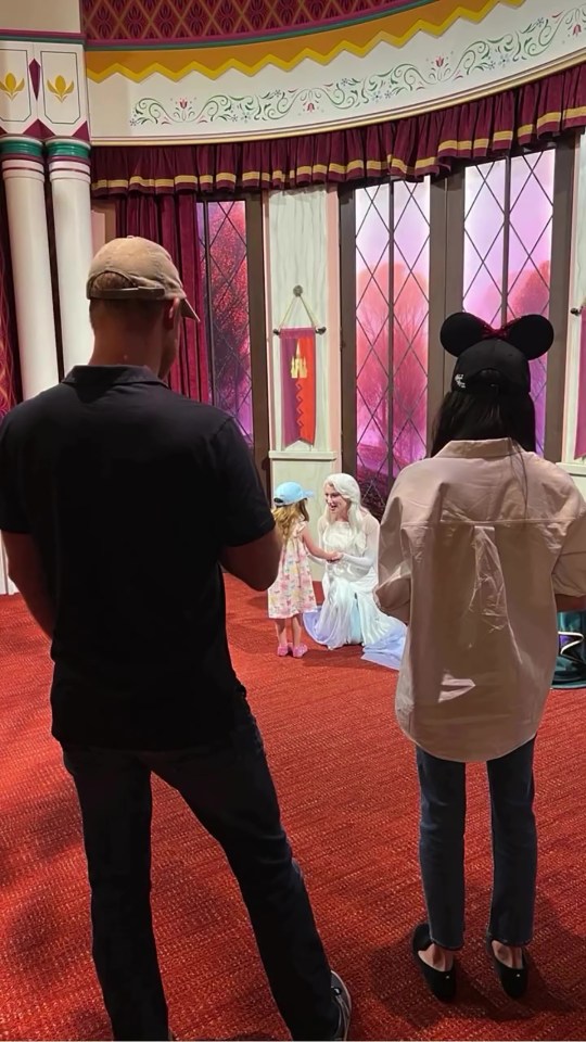Photo of people watching a child meet Elsa at Disneyland.
