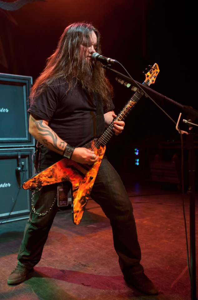 Greg Tribbett of Hellyeah performing with a flame-patterned guitar.
