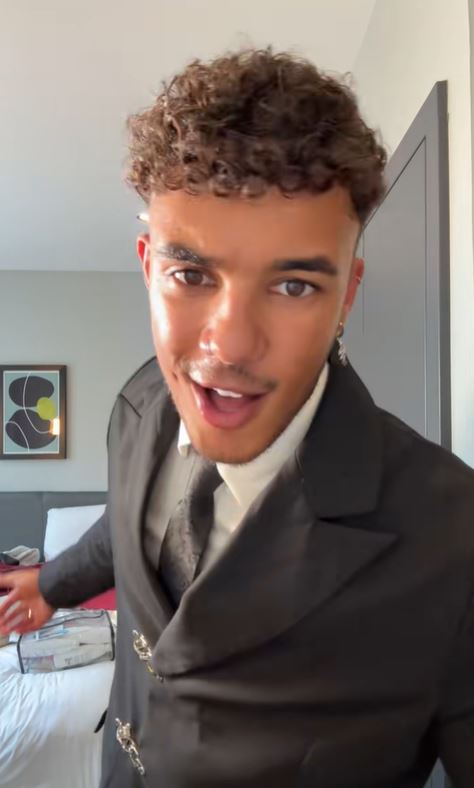 Freddie Fraser in a suit and tie looking at the camera with an open mouth.