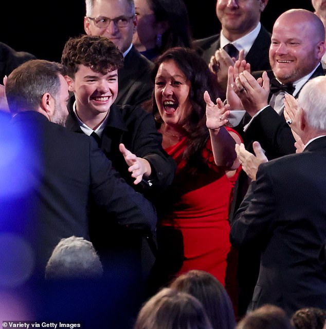 Owen Cooper is cheered on by his parents Noreen (in red) and Andy (right) after becoming the youngest male Emmy winner ever at just 15