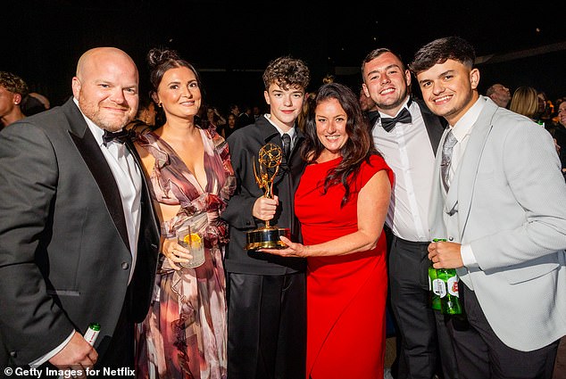 Owen posing with his carer mum Noreen, 52, (third right) and IT worker dad Andy, 45, (far left) who have been credited with keeping the schoolboy's feet on the ground. Pictured with brothers Connor, 31, and 21-year-old Ollie