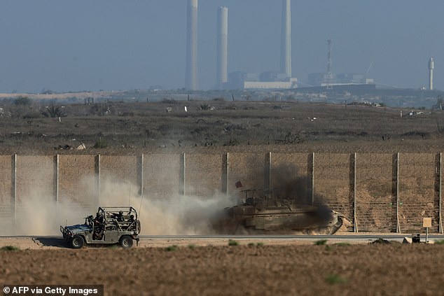 An Israeli military vehicles driving by the border fence with a view of destroyed buildings in the besieged Palestinian territory on September 16, 2025