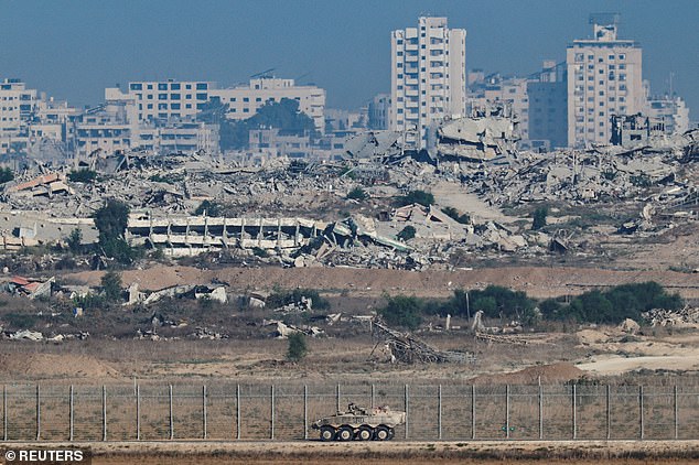 An Armored Personnel Carrier manoeuvres along the Israeli side of the border, as destruction in Gaza is seen in the background, in Israel September 16, 2025