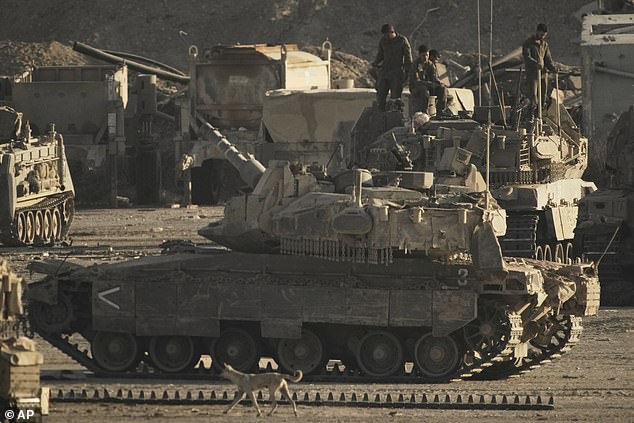 Israeli soldiers work on their tanks and armored personnel carriers (APC) at a staging area on the border with Gaza Strip, as seen from southern Israel, Tuesday, Sept. 16, 2025