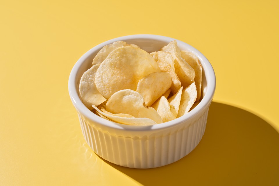 Potato chips in a white bowl.
