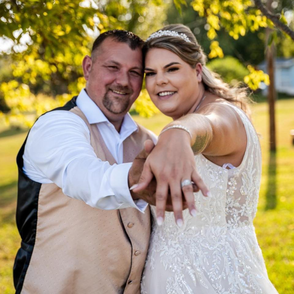 Newlywed couple showing off wedding ring.