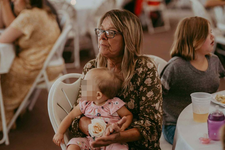 Woman holding a baby at a table.