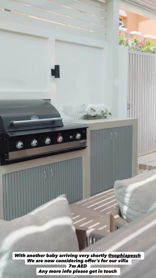 Sophia Peschisolido's Dubai villa for sale, featuring an outdoor kitchen with a black grill and grey cabinets, with "With another baby arriving very shortly @sophiapesch We are now considering offer's for our villa 7m AED Any more info please get in touch" text overlay.