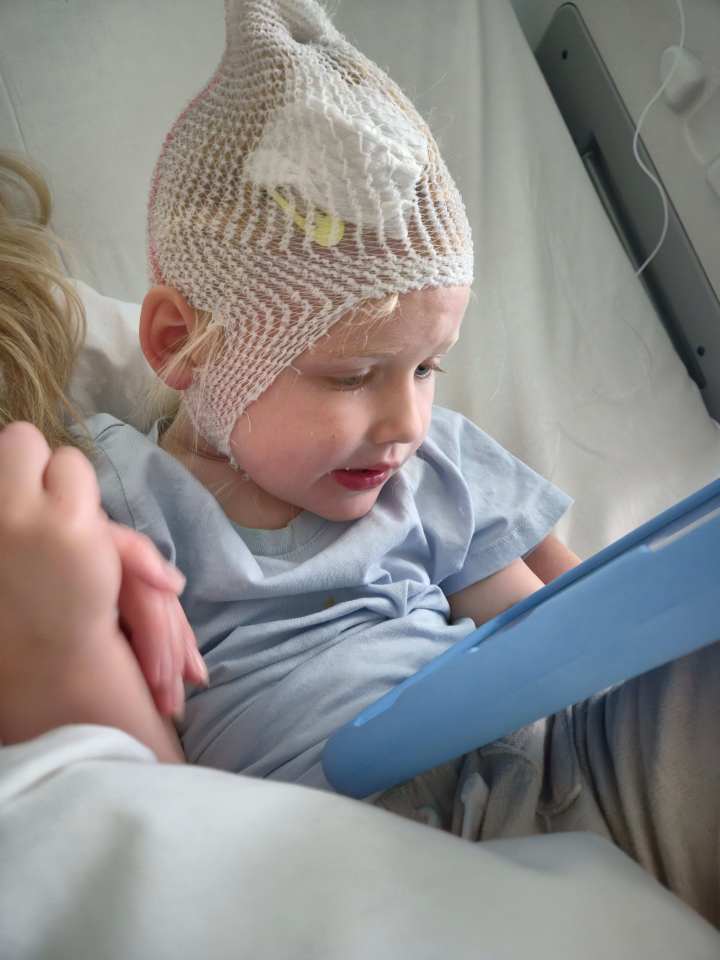 Rosie Bridge with a net cap on her head, looking at a blue tablet.