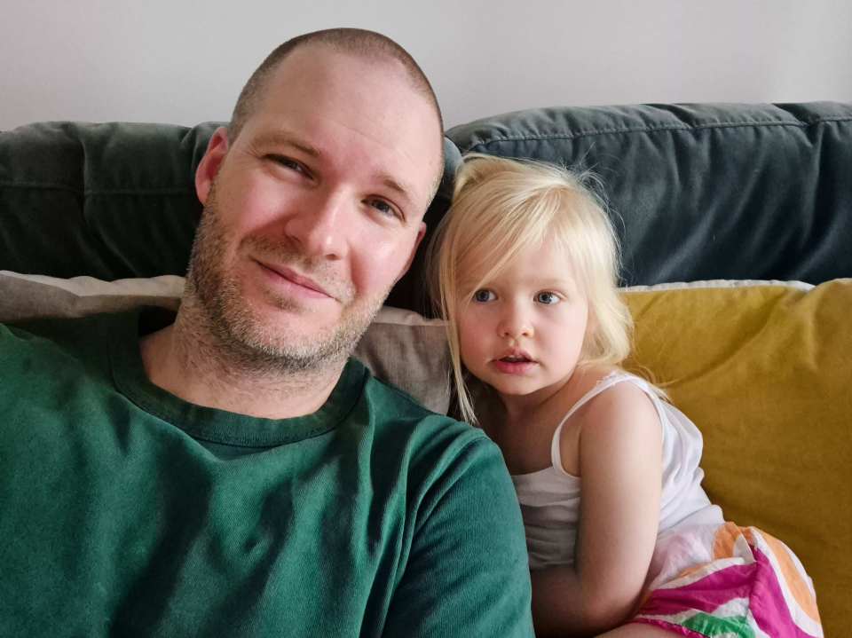 Rosie Bridge, diagnosed with Batten disease CLN2, sits next to an adult man.