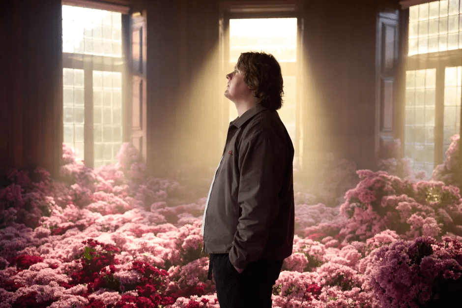 Man standing in a room filled with pink flowers.