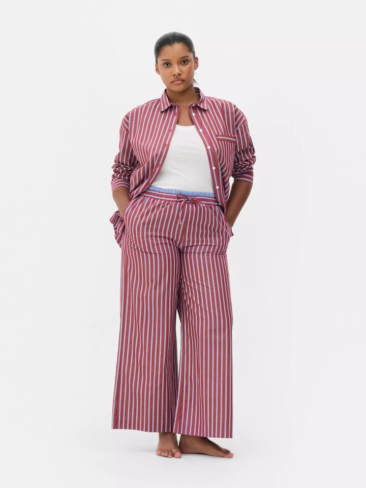 Model wearing a red and blue striped pajama set with a white tank top.