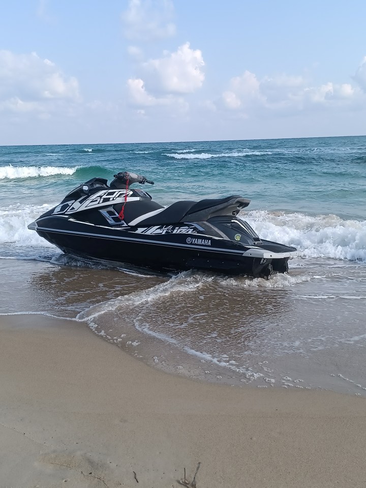 Black jet ski beached at the edge of the ocean.