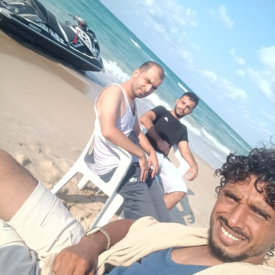 Selfie of Muhammad Abu Dakha with two other Palestinian migrants on a beach with a jet ski nearby, before sailing to Lampedusa, Italy, to seek asylum.
