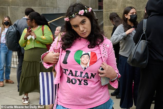 Spectators for Luigi Mangione wait outside of Manhattan Criminal court for a chance to get inside to see him, including this fan wearing a pink shirt that read 'I love Italian boys' with Mangione's face plastered on the heart