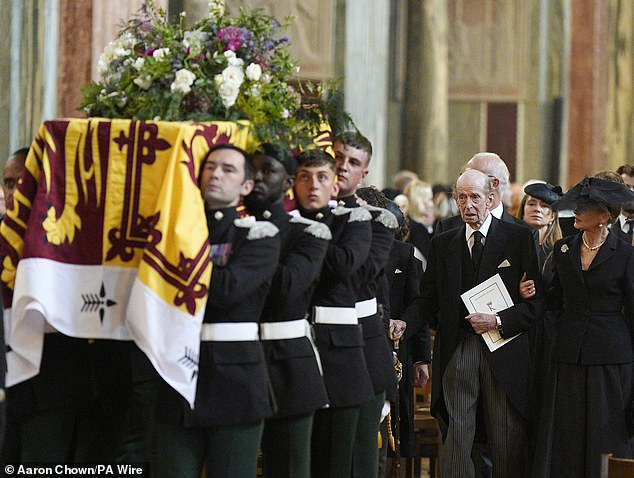 Edward held onto his daughter Helen as they Westminster Cathedral following the service this afternoon