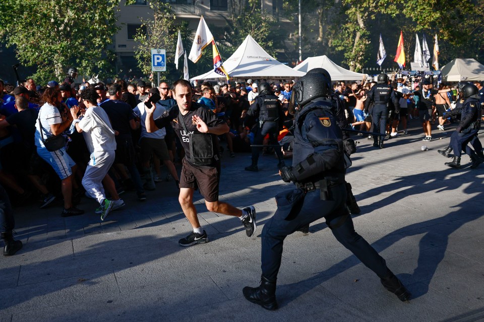 Spanish national police clashing with Olympique de Marseille supporters near Santiago Bernabeu stadium.