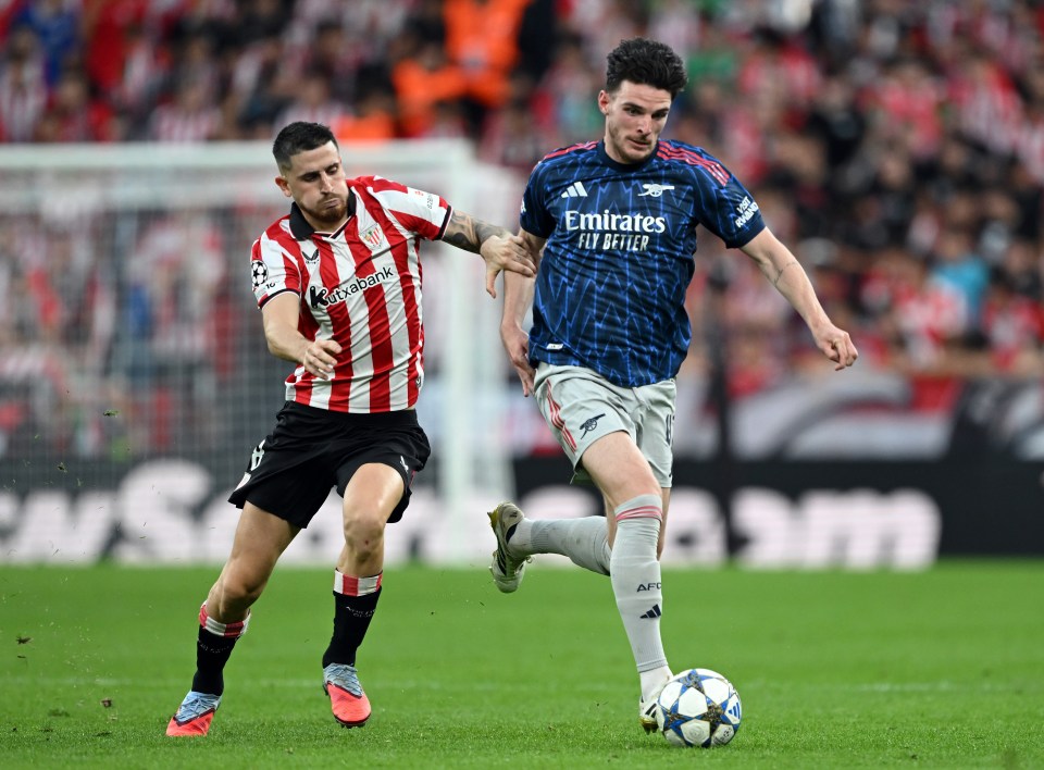 Declan Rice of Arsenal dribbling the ball while Oihan Sancet of Athletic Club attempts to challenge him.