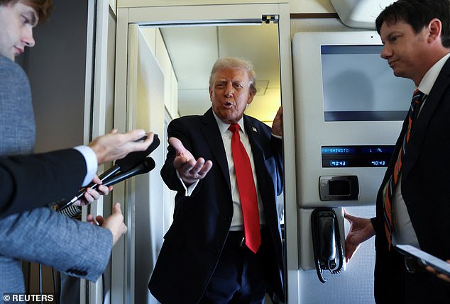 President Donald Trump speaks to reporters aboard Air Force One on his way to his state visit