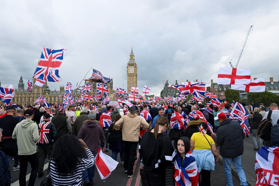 Protesters at an anti-immigration rally in London carrying British flags, with Big Ben in the background.