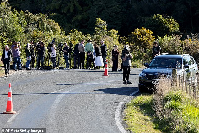 Members of the media stand on the side of a road where a police shootout occurred near the town of Piopio