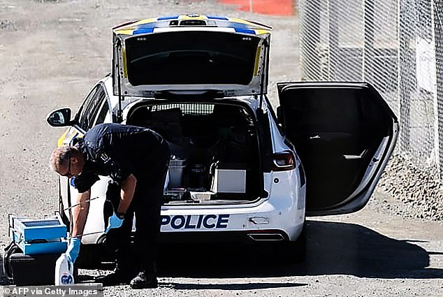 A police officer investigates the site a fatal shootout that occurred near the town of Piopio