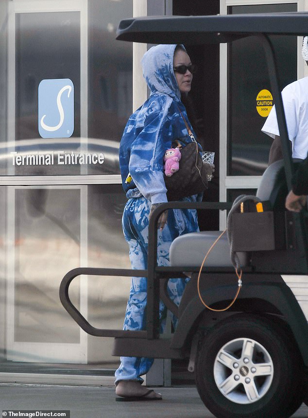Rihanna pictured with a pink Labubu doll attached as a charm on her Louis Vuitton handbag