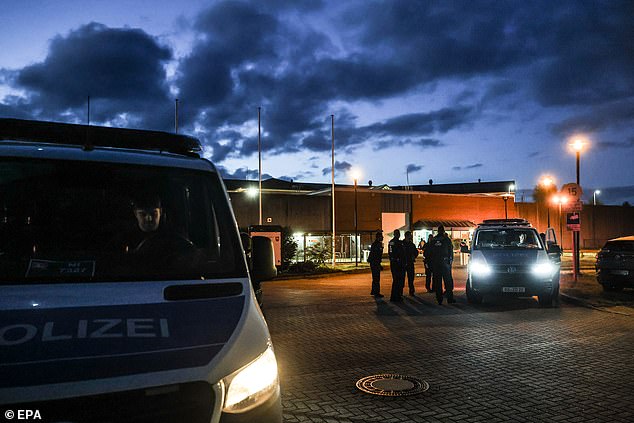 Police officers stand next to the high-security prison in Sehnde, near Hanover, September 17