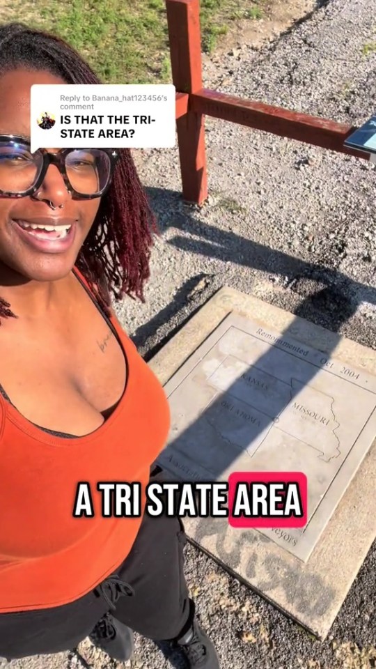 A woman smiling at the camera next to a monument marking the tri-state area of Missouri, Kansas, and Oklahoma.