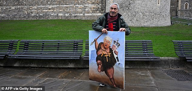 Political satire artist Kaya Mar holds a painting depicting the US President Donald trump and Britain's King Charles III, outside Windsor Castle, in Windsor, on September 17, 2025, during US President Donald Trump's second State Visit to the UK. US President Donald Trump arrived in Britain on Tuesday for an unprecedented second state visit, with the UK government rolling out a royal red carpet welcome to win over the mercurial leader. (Photo by Paul ELLIS / AFP) (Photo by PAUL ELLIS/AFP via Getty Images)