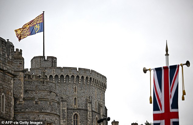 A gigantic royal standard is pictured flying from the Royal Tower of Windsor Castle today